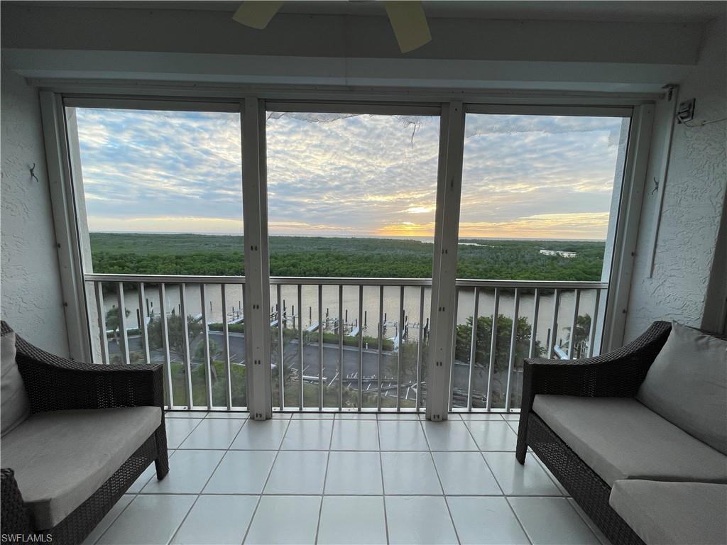 13105 Vanderbilt Drive, Unit 802 Naples, FL 34110 - Photo 3 of 32 a living room with a large window and a table