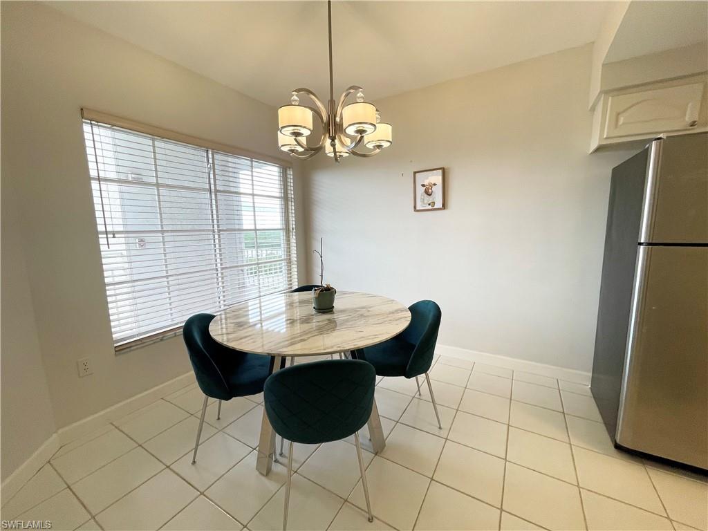 13105 Vanderbilt Drive, Unit 802 Naples, FL 34110 - Photo 6 of 32 a dining room with a table and chairs
