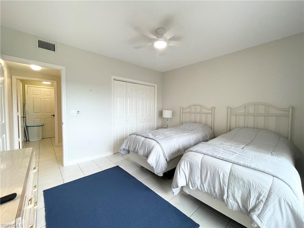 13105 Vanderbilt Drive, Unit 802 Naples, FL 34110 - Photo 9 of 32 a bedroom with two beds and painted walls