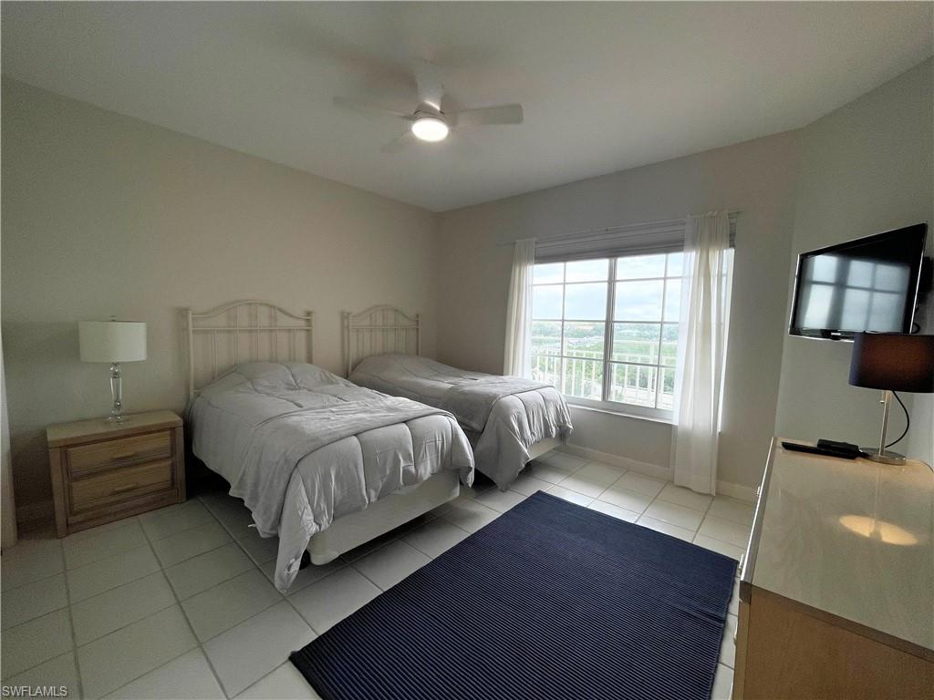 13105 Vanderbilt Drive, Unit 802 Naples, FL 34110 - Photo 10 of 32 a bedroom with a bed and large window