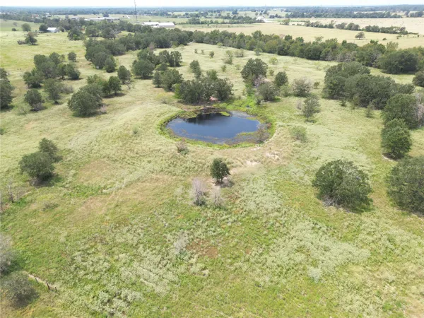 an aerial view of field with trees
