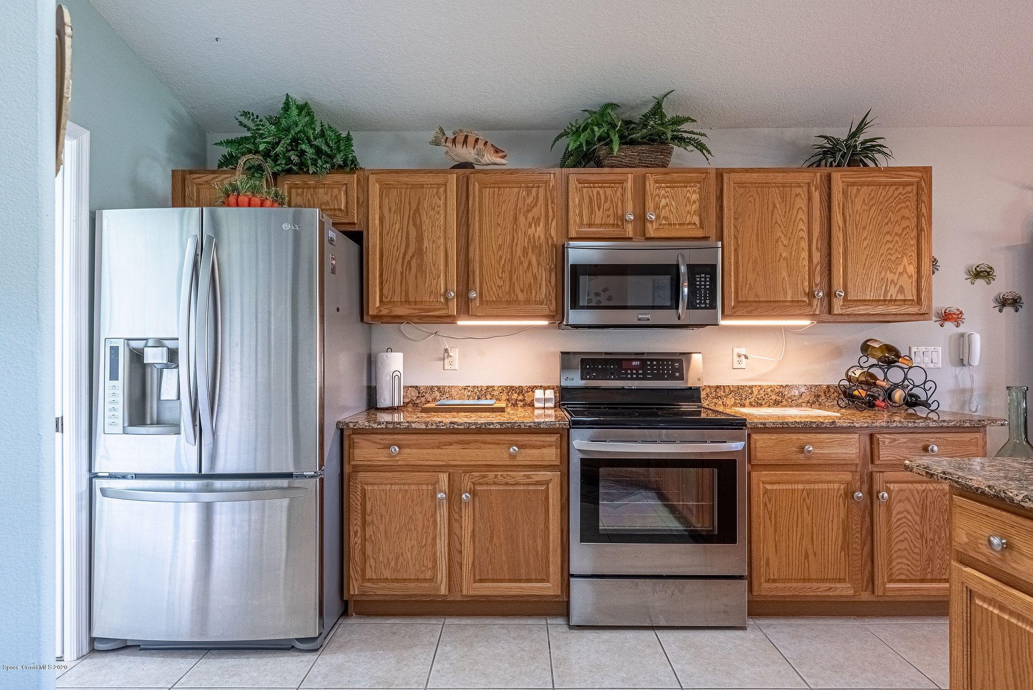 619 Cottonwood Road Sebastian, FL 32958 - Photo 22 of 50 a kitchen with granite countertop a stove top oven and refrigerator