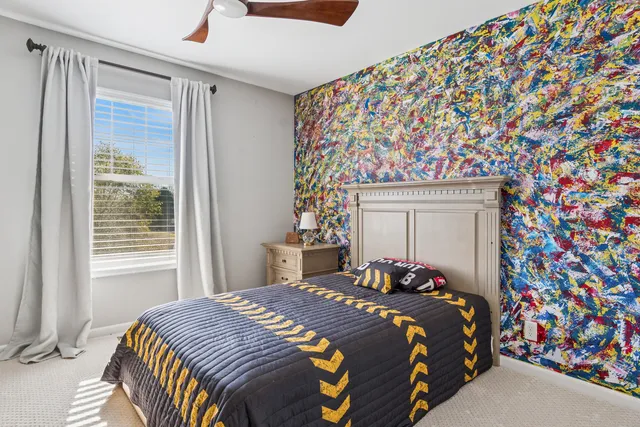 a bedroom with a bed and a lamp next to a window