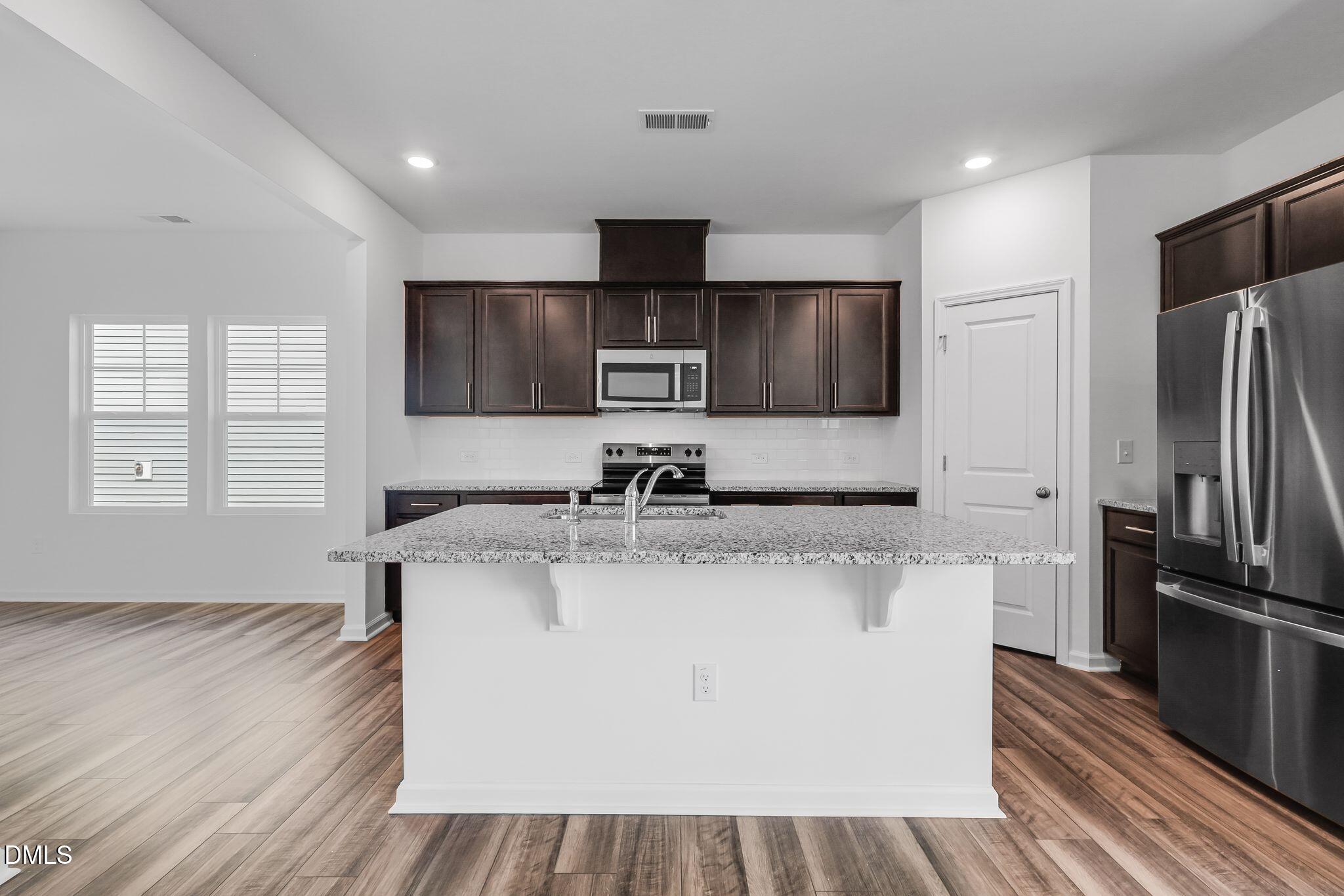 5818 Millstone Way Sims, NC 27880 - Photo 11 of 24 a kitchen with stainless steel appliances granite countertop a sink stove and refrigerator