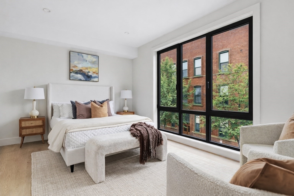 118 B Street, Unit 103 Boston, MA 02127 - Photo 3 of 12 a bedroom with a bed and a large window