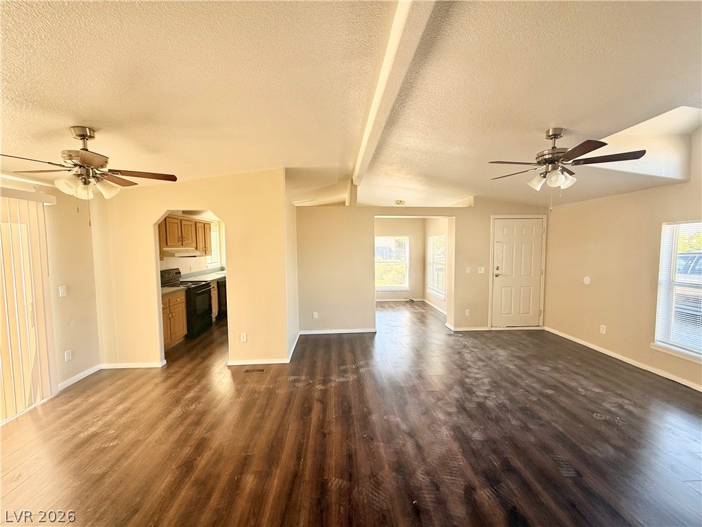 6450 Vicki Ann Road Pahrump, NV 89048 - Photo 2 of 9 A spacious living area with warm wood-look flooring and dual ceiling fans offers comfortable daily living.