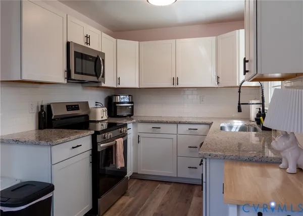 a kitchen with granite countertop cabinets stainless steel appliances and wooden floor