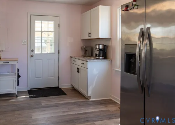 a kitchen with stainless steel appliances granite countertop a refrigerator a stove and a sink with wooden floor