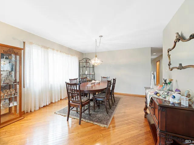 a dining room with furniture window and wooden floor