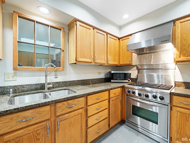 a kitchen with granite countertop a sink stainless steel appliances and cabinets