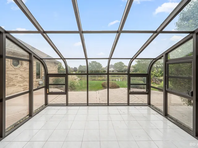 a view of an empty room with a large window with kitchen view
