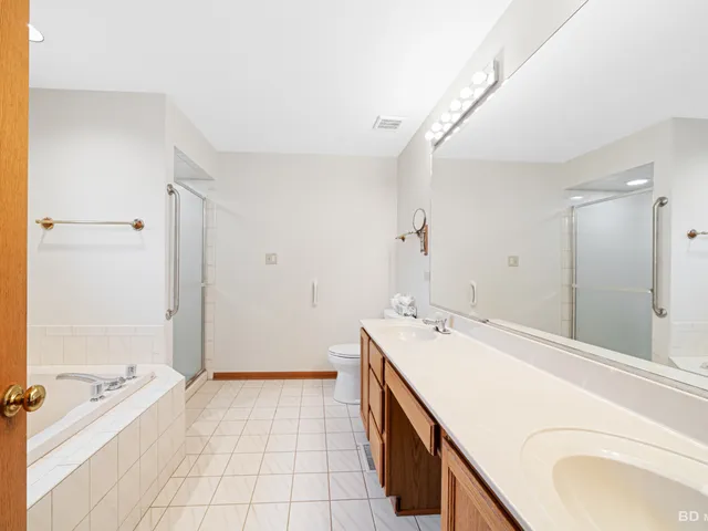 a spacious bathroom with a tub sink and mirror