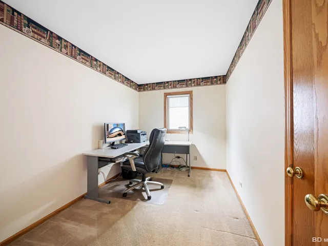 a view of a workspace with furniture and a window