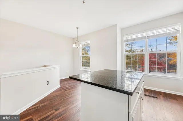 a kitchen with granite countertop a sink cabinets and wooden floor