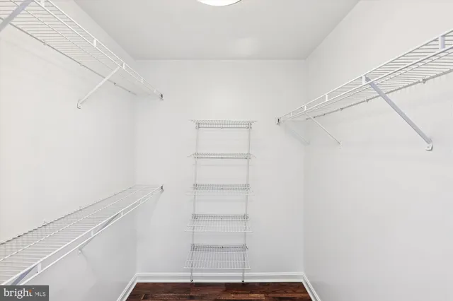 a view of walk in closet with empty racks