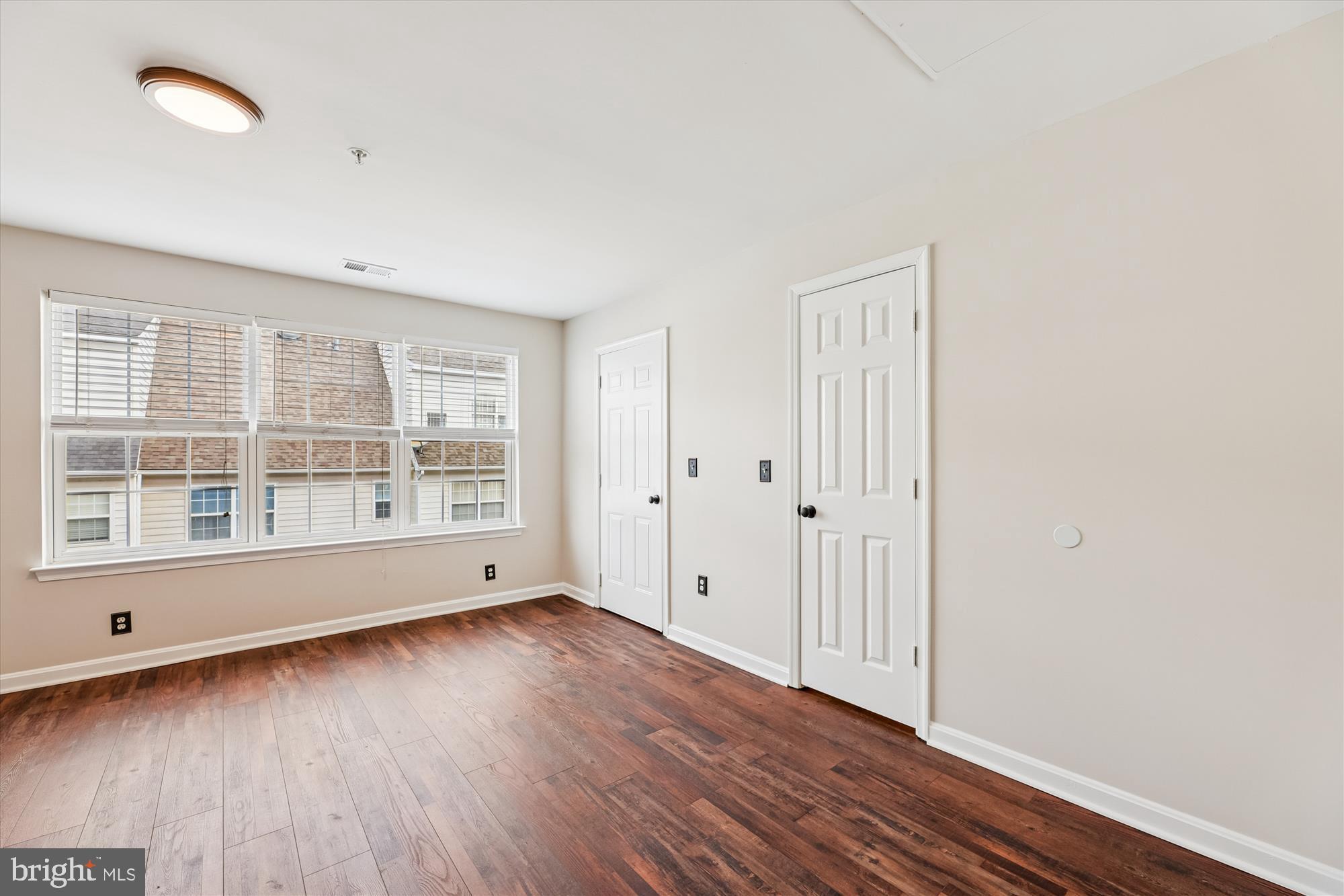 3811 Eisenhower Avenue Alexandria, VA 22304 - Photo 38 of 56 an empty room with wooden floor and windows