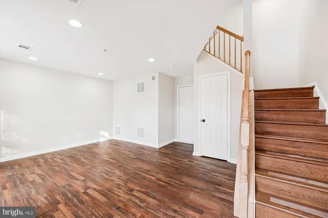 a view of a hallway with wooden floor and staircase