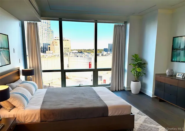 a bedroom with a large bed and a potted plant