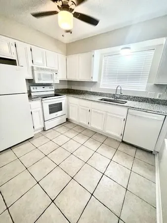 a kitchen with a stove a sink and a refrigerator