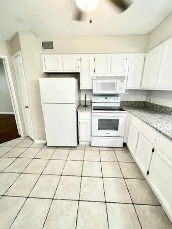 a kitchen with cabinets and white appliances