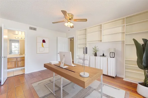 a view of a workspace with furniture and a window