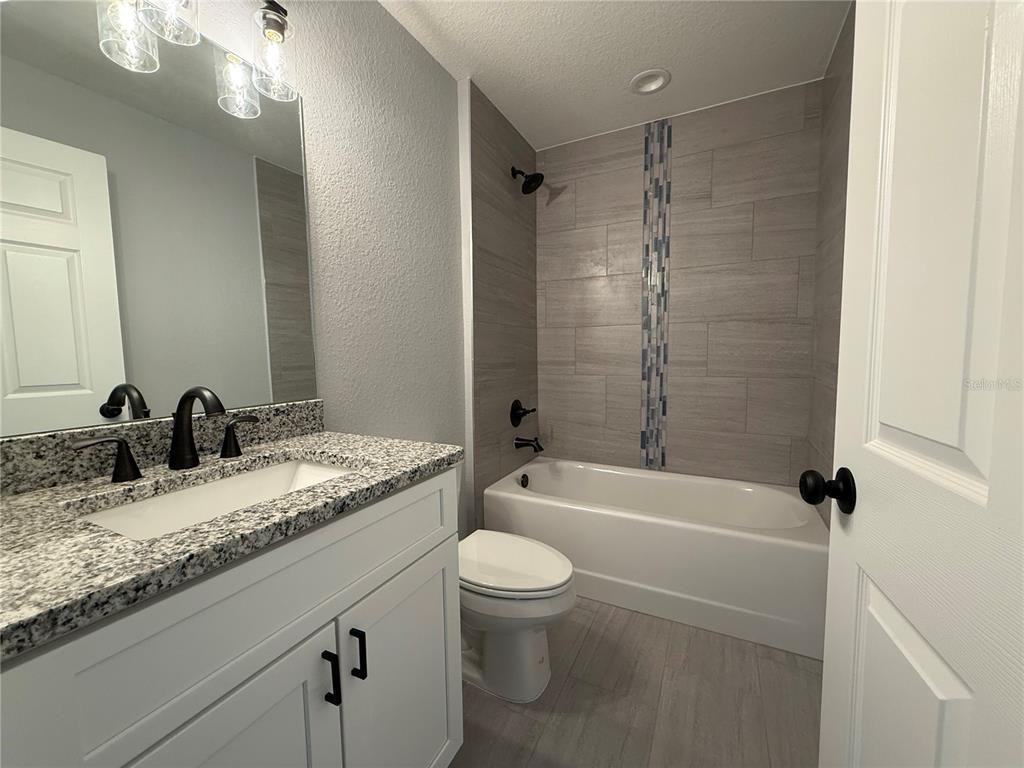 48 Locust Drive Ocala, FL 34472 - Photo 7 of 12 a bathroom with a granite countertop sink a toilet and bathtub