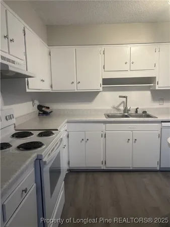 a kitchen with granite countertop white cabinets and white appliances