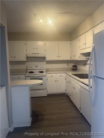 a kitchen with cabinets appliances a sink and a counter top space