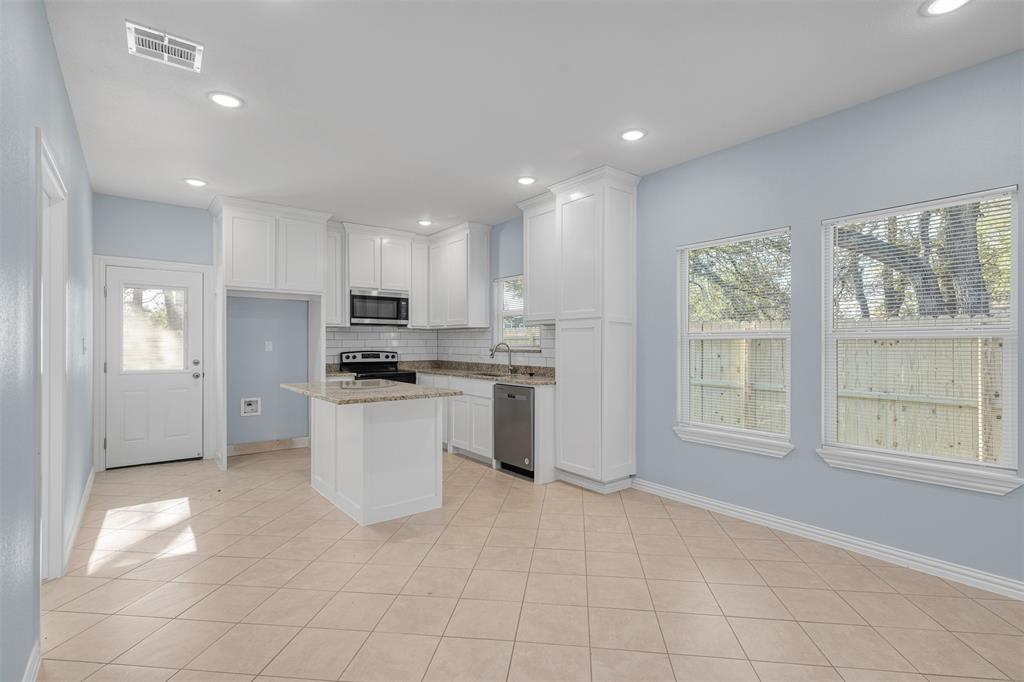 3005 Blackjack Lane Granbury, TX 76048 - Photo 17 of 30 a kitchen with a refrigerator and white cabinets