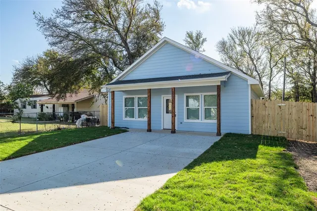 a front view of a house with a yard and trees