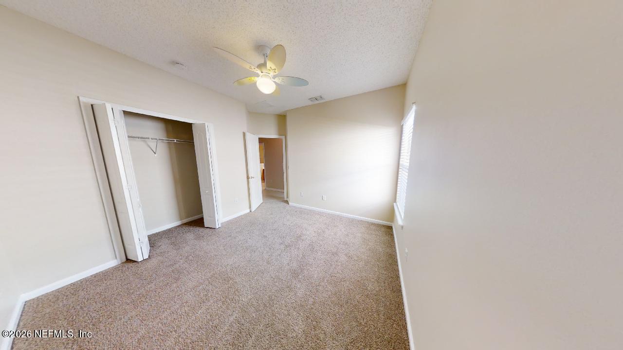 14454 Millhopper Road Jacksonville, FL 32258 - Photo 27 of 44 a view of a room with a chandelier fan and closet