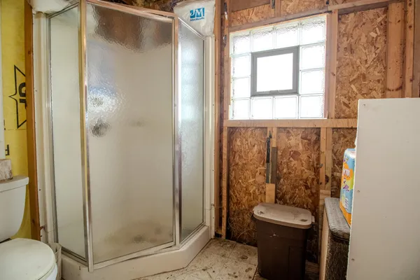 a bathroom with a toilet and a shower