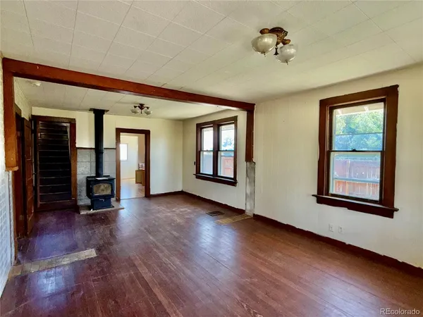 a view of a big room with wooden floor and windows