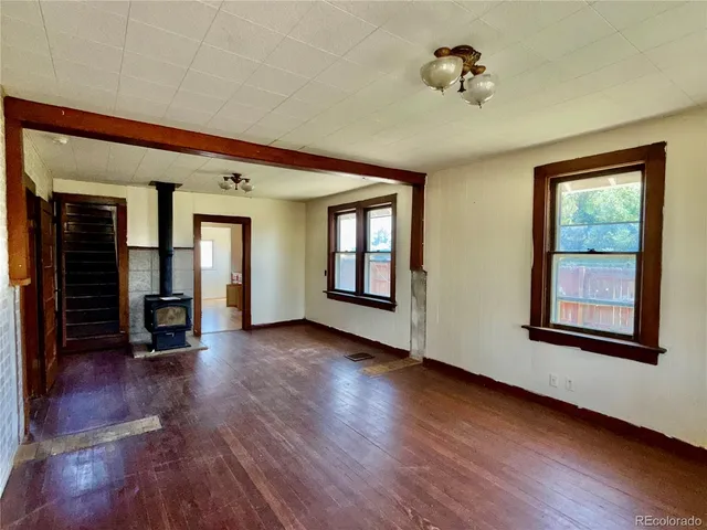 a view of a big room with wooden floor and windows