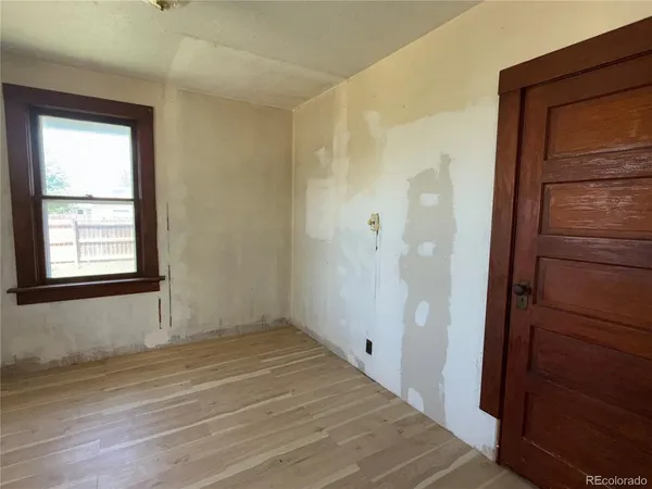 a view of an empty room with closet and a window