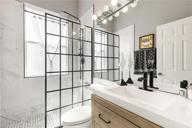 a bathroom with a sink a toilet and shower