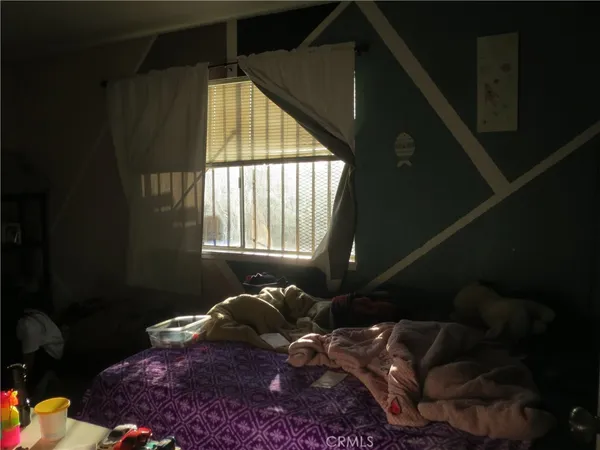 a bed sitting in a bedroom next to a window
