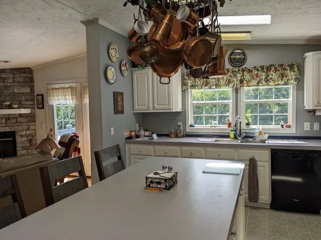 a kitchen with a stove a sink a microwave and cabinets