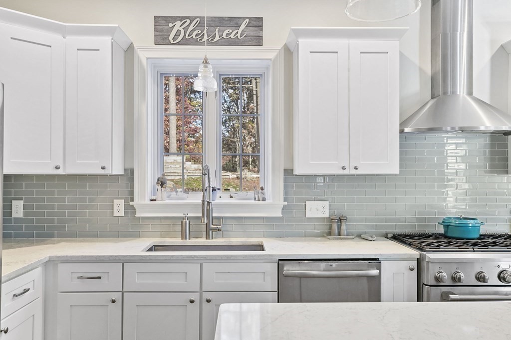 455 Broadway Hanover, MA 02339 - Photo 9 of 26 a kitchen with stainless steel appliances granite countertop a sink a stove and a white wooden cabinets