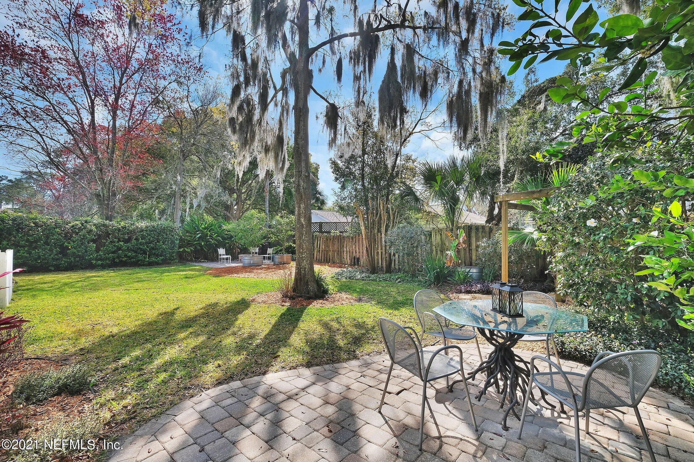 1614 Dunsford Road Jacksonville, FL 32207 - Photo 21 of 24 a view of a backyard with table and chairs and potted plants and large trees