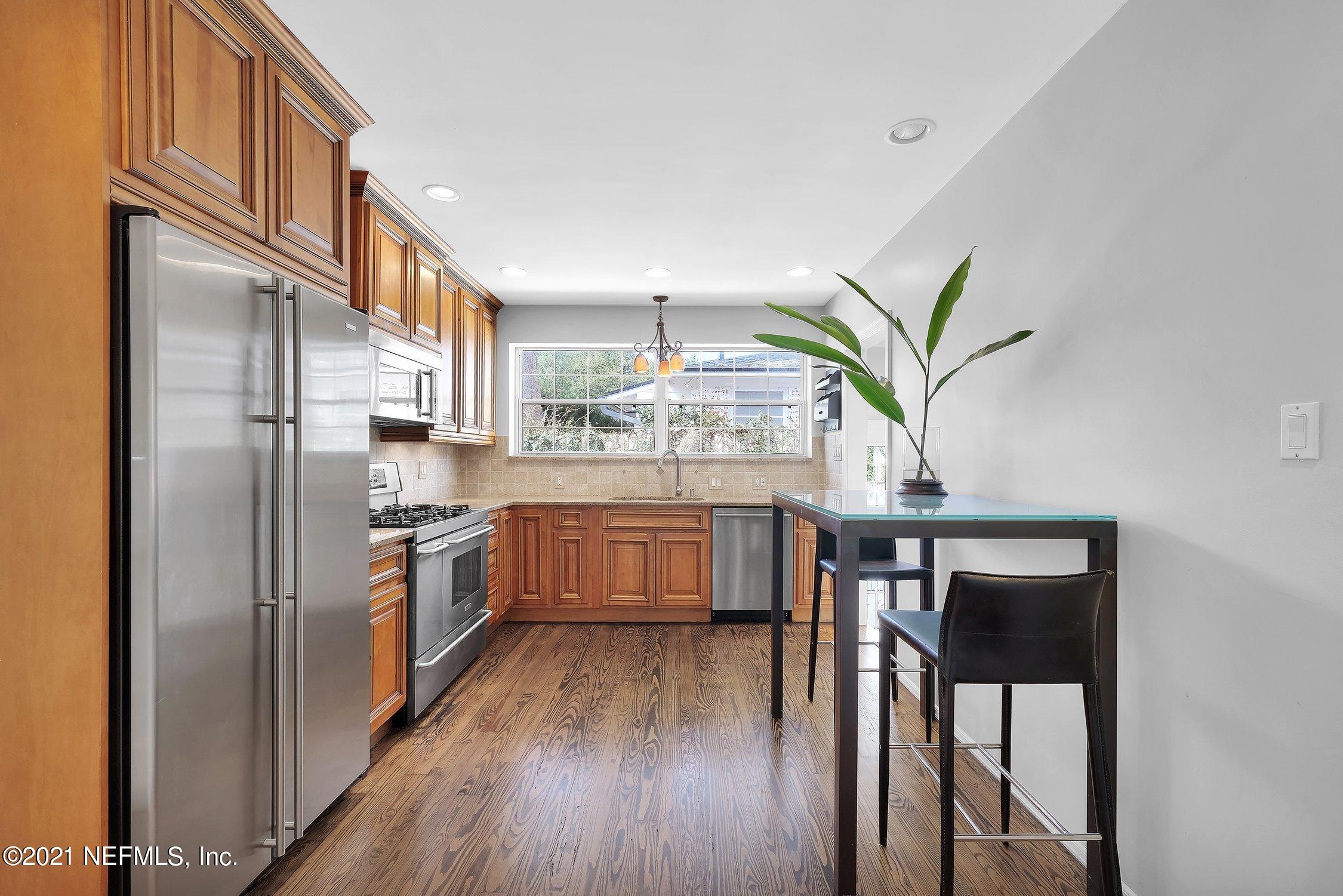 1614 Dunsford Road Jacksonville, FL 32207 - Photo 8 of 24 a kitchen with stainless steel appliances a dining table chairs wooden floors and a view of living room