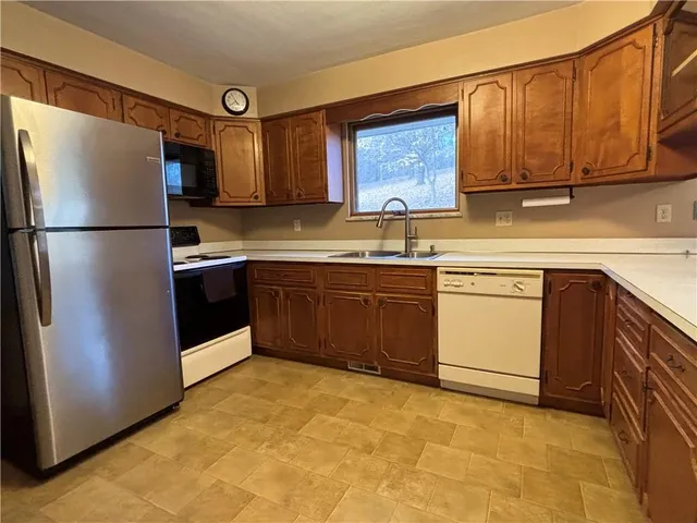 a view of a kitchen with wooden floor and a window