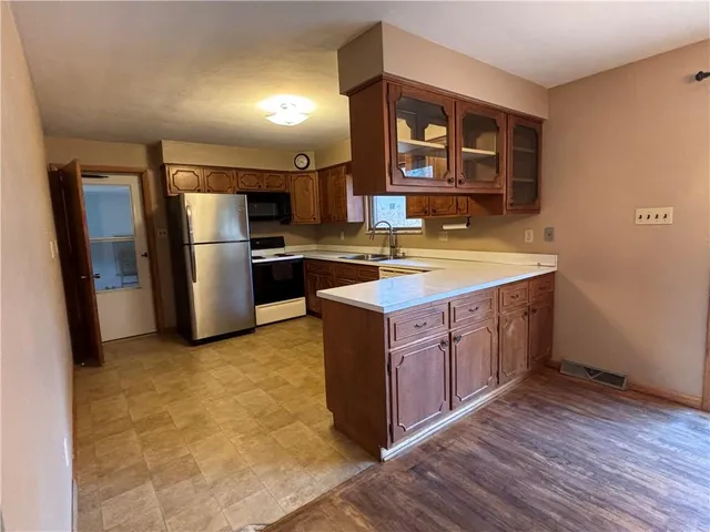 a view of an empty room with a chandelier fan