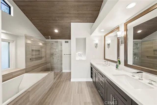 a bathroom with a granite countertop sink a large mirror a bathtub and next to a window