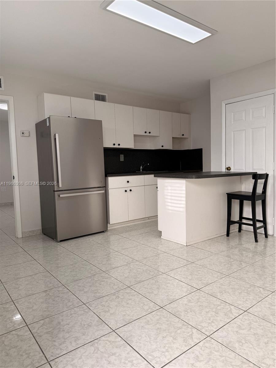 a kitchen with stainless steel appliances a refrigerator sink and cabinets