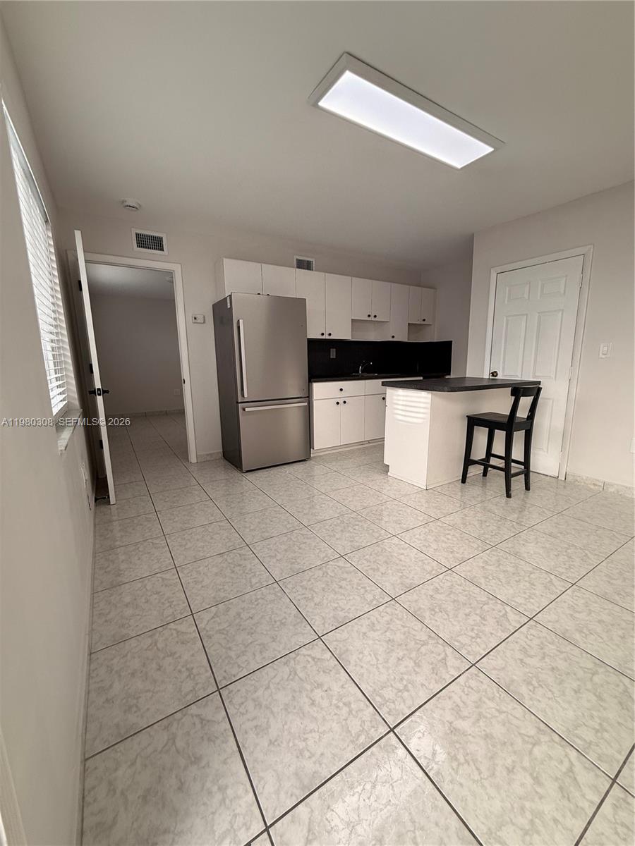 3666 Southwest 24th Terrace, Unit R Miami, FL 33145 - Photo 3 of 10 a kitchen with stainless steel appliances a refrigerator sink and cabinets