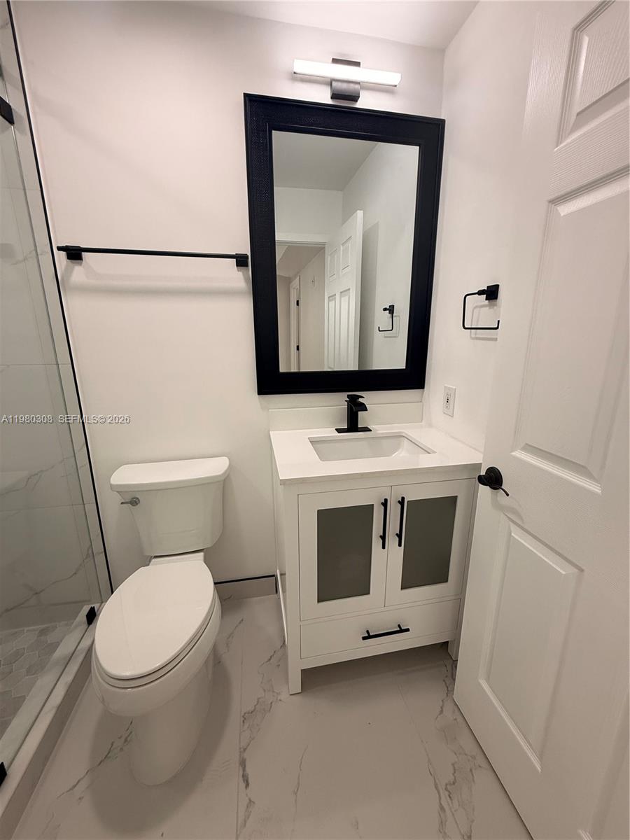 3666 Southwest 24th Terrace, Unit R Miami, FL 33145 - Photo 7 of 10 a bathroom with a toilet sink and mirror