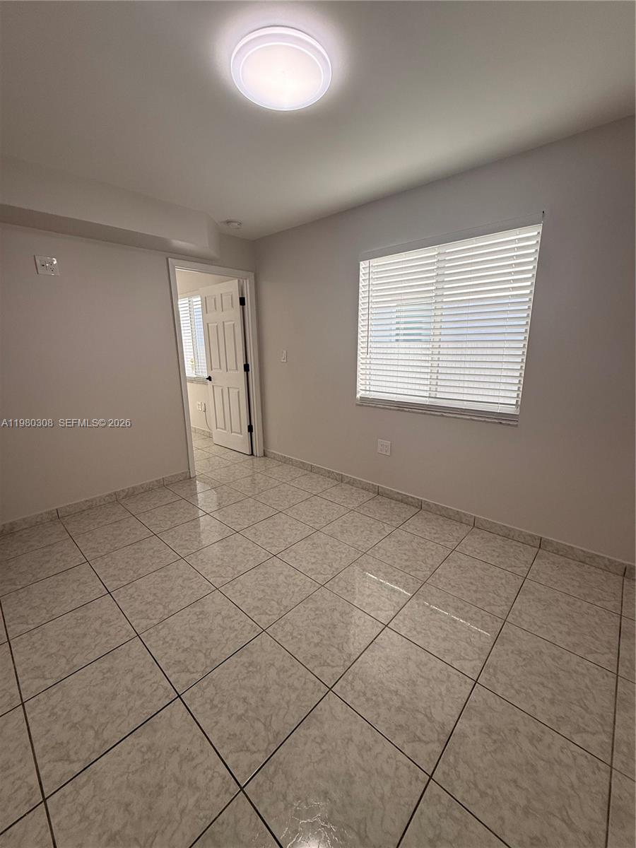 3666 Southwest 24th Terrace, Unit R Miami, FL 33145 - Photo 9 of 10 an empty room with a empty space and a window
