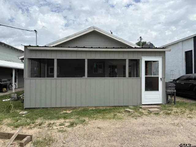 a view of a house with a small yard and a large parking space