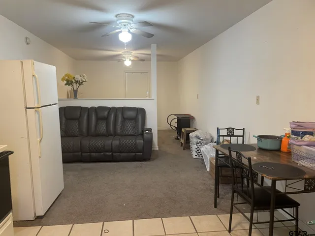 a living room with furniture a chandelier and a dining table